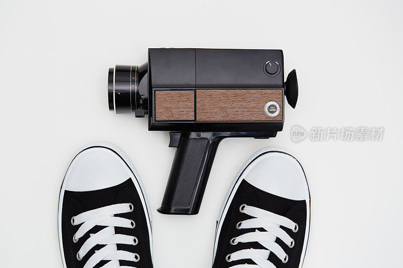 老式模拟Super8, 8毫米胶片电影相机和白色背景运动鞋